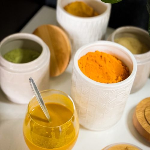 Golden Milk recipe in glass with ingredients in ceramic recipient